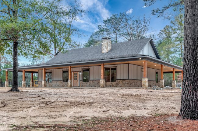 Randall RP-10004 single story barndominium with a wrap around porch, cedar columns on stone bases