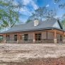 Randall RP-10004 single story barndominium with a wrap around porch, cedar columns on stone bases